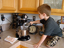 Hunter helps mix more frosting.
