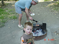 Dave grills some hot dogs.