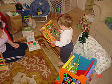 Hunter looking at his dinosaur book and finger puppets from auntie Tanya.