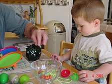 Daddy helps Hunter put his money in his bank.