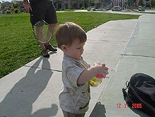 Hunter helps daddy open his tennis balls at the park.