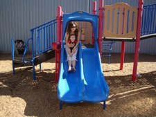 Ryder goes down the slide with mom.
