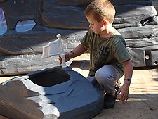 Hunter puts the flag on his climbing rock.